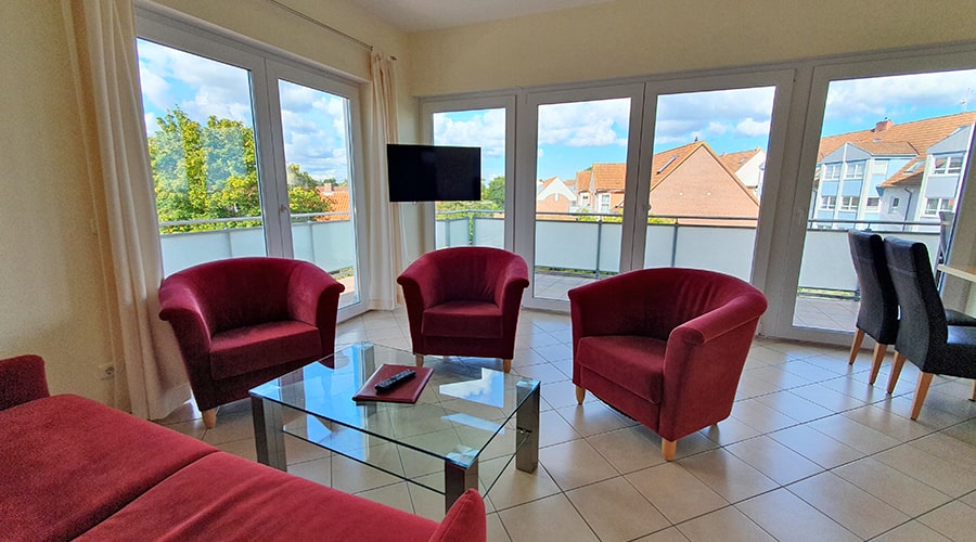 Paar entspannt im Bett und isst Erdbeeren unter einem Wandbild mit Fischerboot